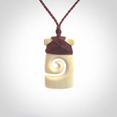 Hand carved Woolly Mammoth Tusk toki with koru pendant. Toki with koru necklace carved from ancient woolly mammoth tusk. Provided with adjustable cord and packaged in a woven kete pouch.